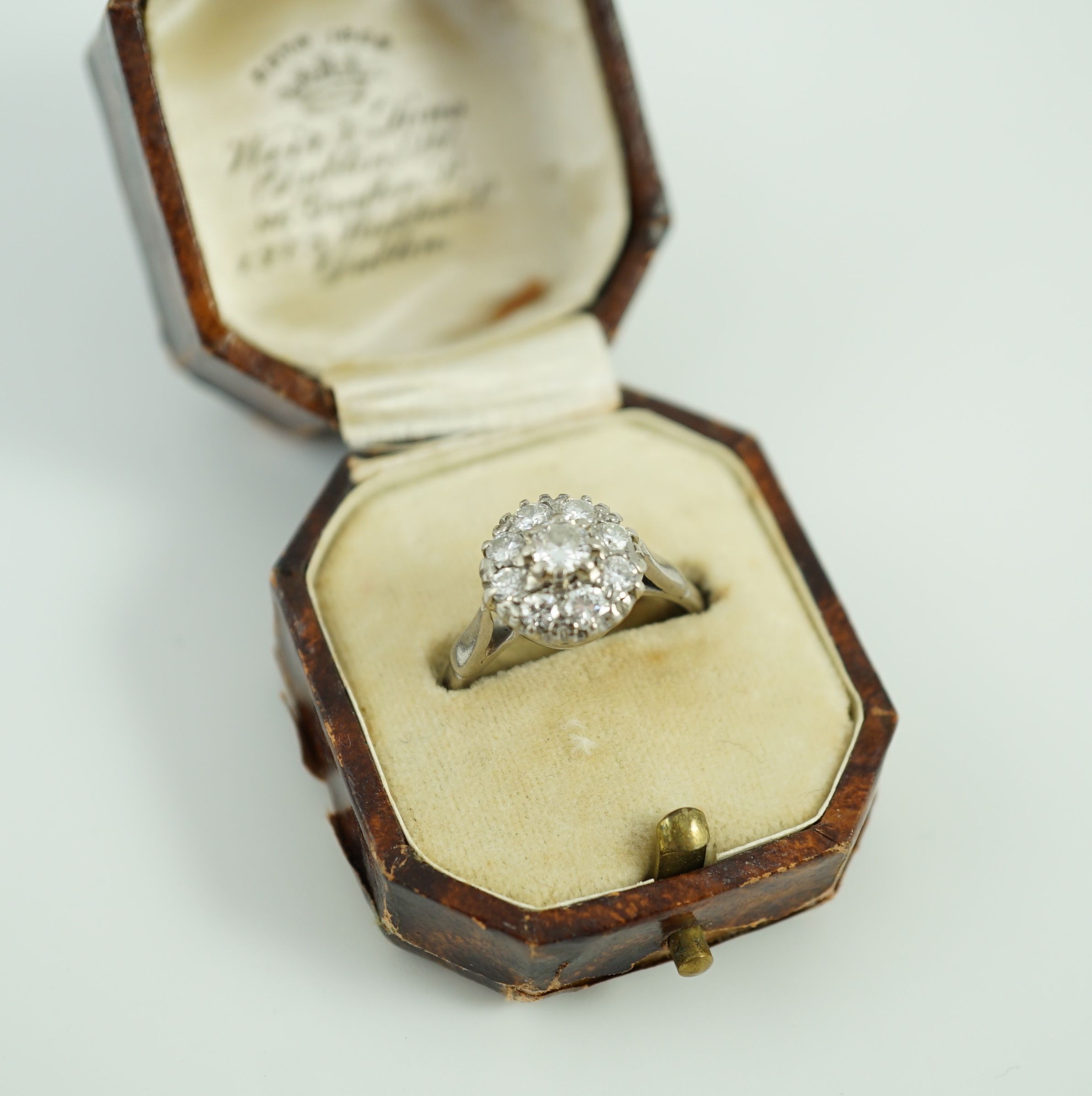 An 18ct white gold and nine stone diamond flower head cluster ring